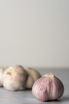 Bulbs of purple garlic on a light surface 