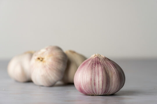 Bulbs of purple garlic on a light surface 