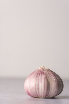 Bulb of purple garlic on a light surface 