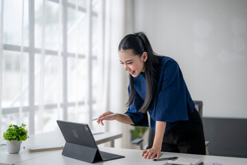 Young asian businesswoman using digital tablet and stylus pen in modern office