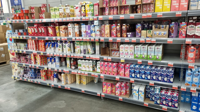 supermarket shelf with a large selection of drinks and dairy products in tetra pack cardboard packaging.  