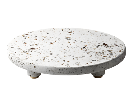 White speckled round coaster with three feet.