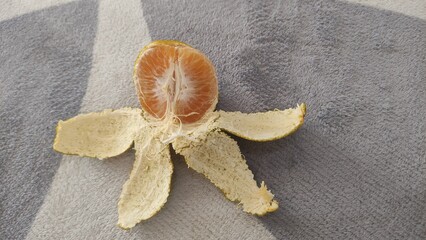Fresh peeled orange with skin open on a table. Perfect food photography for health, diet, vitamin, and nutrition concepts. Ideal for buyers in culinary business, advertising, restaurants, blogs, and e