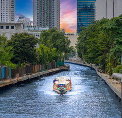 Fototapeta premium Ferry boat going through a Canal Khlong in Thai running from Asoke Soi 21 Sukhumvit Rd NANA to Siam and Platunam in BKK Bangkok Thailand