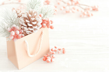 Pink bag filled with pinecones, berries, and frosted fir branches, ideal for festive decorations, holiday designs, winter themes, and christmas concepts.
