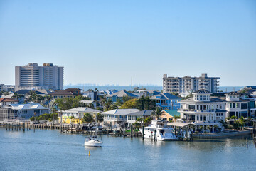Obraz premium Sailboat passing by waterfront homes in Fort Myers Beach on Estero Island, southwest Florida in Lee County