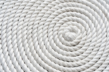 Closeup of white rope spiral coil texture background, natural fiber pattern symbolizing strength, durability, nautical, construction, and rustic design, perfect for creative projects and materials.