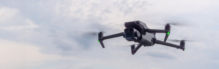 Drone soaring through the cloudy sky during the day capturing aerial views and landscape exploration. quadcopter close-up on the background of cloudy sky panorama