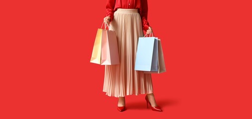 Young woman with shopping bags on red background. Black Friday sale