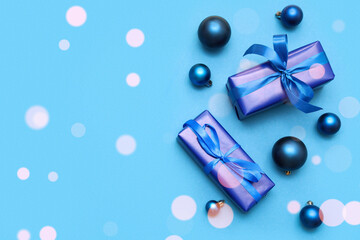 Festive composition with gift boxes and Christmas baubles on blue background