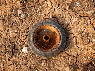Rusted Wheel with old rubber on Cracked soil