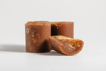 cylindrical block of palm sugar on white background