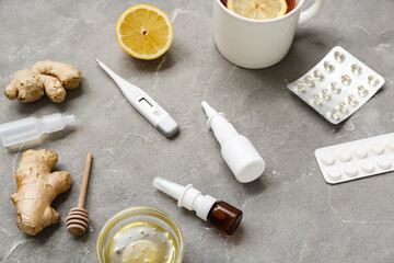 Nasal drops with lemon tea, ginger, honey and pills on grunge background