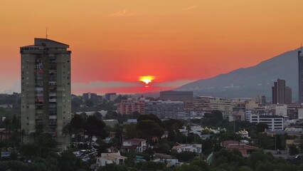 The stunning sunset casts a glow over the vibrant cityscape, showcasing impressive architecture