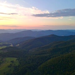 Naklejka premium Aerial view of a mountain range at sunset. Soft colors, hazy