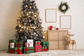 Christmas tree with gift boxes, festive decorations and wooden cabinet near white brick wall