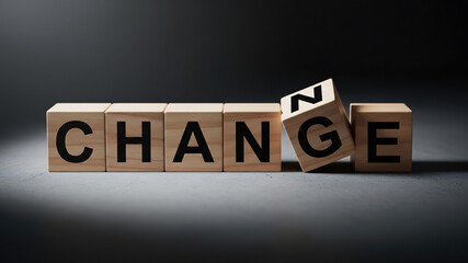 Wooden blocks spelling out the word change with one block falling