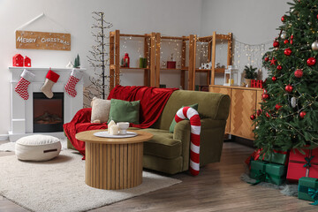 Interior of living room with green sofa, fireplace, Christmas tree and festive decorations