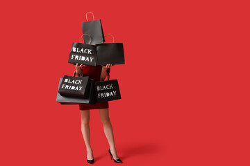 Young woman with shopping bags on red background. Black Friday Sale