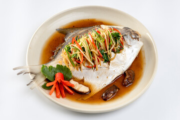 Steamed sea bass with soy sauce on a white background