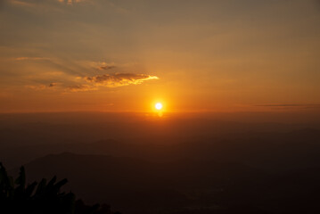 Dramatic sunset over mountain landscape. Beautiful landscape foggy hills twilight time. Blue golden sky sunrise dramatic beautiful landscape mountain. Dawn sky gold dusk time cloudscape with sunlight