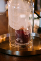 Cold smoke liquor. Alcoholic beverage. Fragrant drink served on metal bar tray. Professional equipment for cocktail technique preparation.