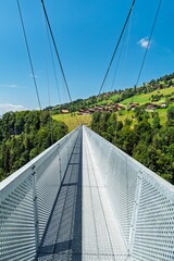 Obraz premium Walk across a breathtaking suspension bridge in Switzerland, Canton Bern. Experience stunning views and unique designs perfect for tourism and adventure promotions.