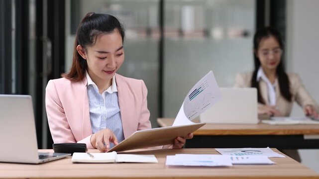 Accountant working with financial documents at office desk.