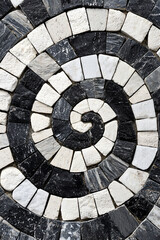 Fototapeta premium Artistic Spiral Pattern of Black and White Stone Tiles Mosaic Design