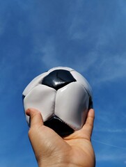 Hand holding a soccer ball