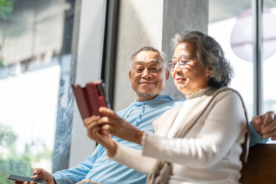 Senior asian couple using smartphone together for telehealth services, online doctor consultation, elderly care, digital health support, medical apps, healthtech and digital connection in retirement