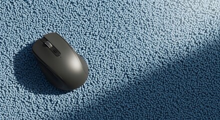 Black Wireless Computer Mouse on Light Blue Textured Rug.