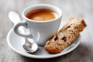 Cup of espresso with biscotti on saucer