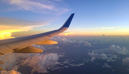 Obraz premium Airplane wing over sunset cloudscape