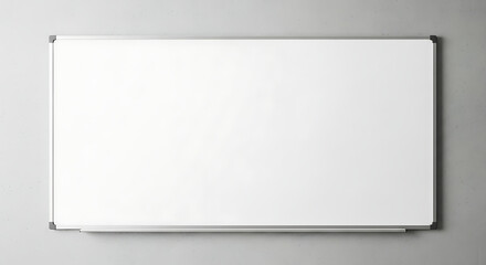A blank white dry erase board with a silver frame mounted on a light gray wall in a well lit room