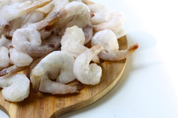 Frozen shrimps on wooden board.