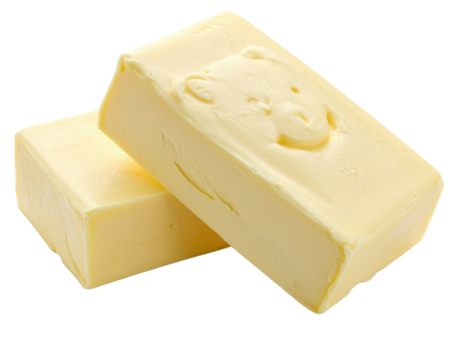 Two blocks of creamy yellow butter with a playful bear embossed on one surface, showcasing smooth texture and rich color.
