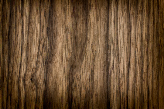 background is made of old wood. an old dark brown board. the texture of a rustic table. american valnut, a place for a text or object, frame, vignetting, view. the effect of aging, horizontal