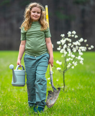 Child farmer plant and watering tree in spring garden. Spring activity of plant trees. Kid work...