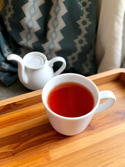 Warm and Inviting Cup of Hot Tea on a Wooden Tray in Cozy Setting.