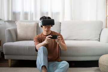 Young Asian man gamer wearing virtual reality touching air during the VR experience  Future home...