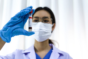 Scientist holding Coronavirus covid-19 infected blood sample tube DNA testing of the blood in the...