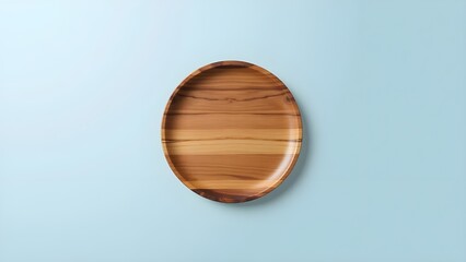 A round wooden plate rests against a soft blue background, highlighting its natural charm. The smooth surface reveals subtle grain patterns and warm, earthy tones.