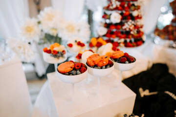 Colorful fruit desserts displayed elegantly at a festive gathering in a banquet hall