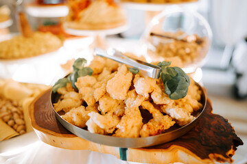Crispy fried chicken served on a stylish wooden platter at a festive gathering