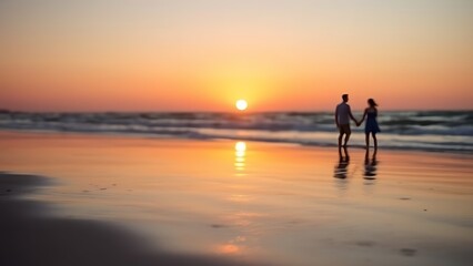 Fototapeta premium Sunset at the beach with golden light and distant silhouettes of a family.