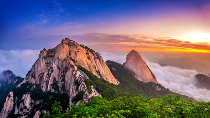 Bukhansan mountains is covered by morning fog and sunrise in Seoul,Korea.(Dark tone)