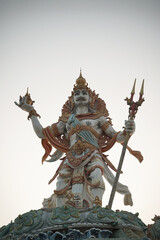 A powerful statue of the Hindu sea god, Baruna, holding a trident. Detailed sculpture representing Balinese mythology, religion, and culture.