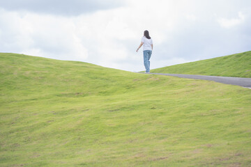 Relax and wellness concept with woman walk on road in garden and mountain background at chiangmai thailand in raining season