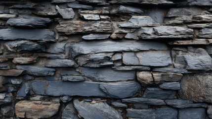 Fototapeta premium Rustic slate stone wall background shows rugged texture. This detailed rock pattern provides feeling of solidity